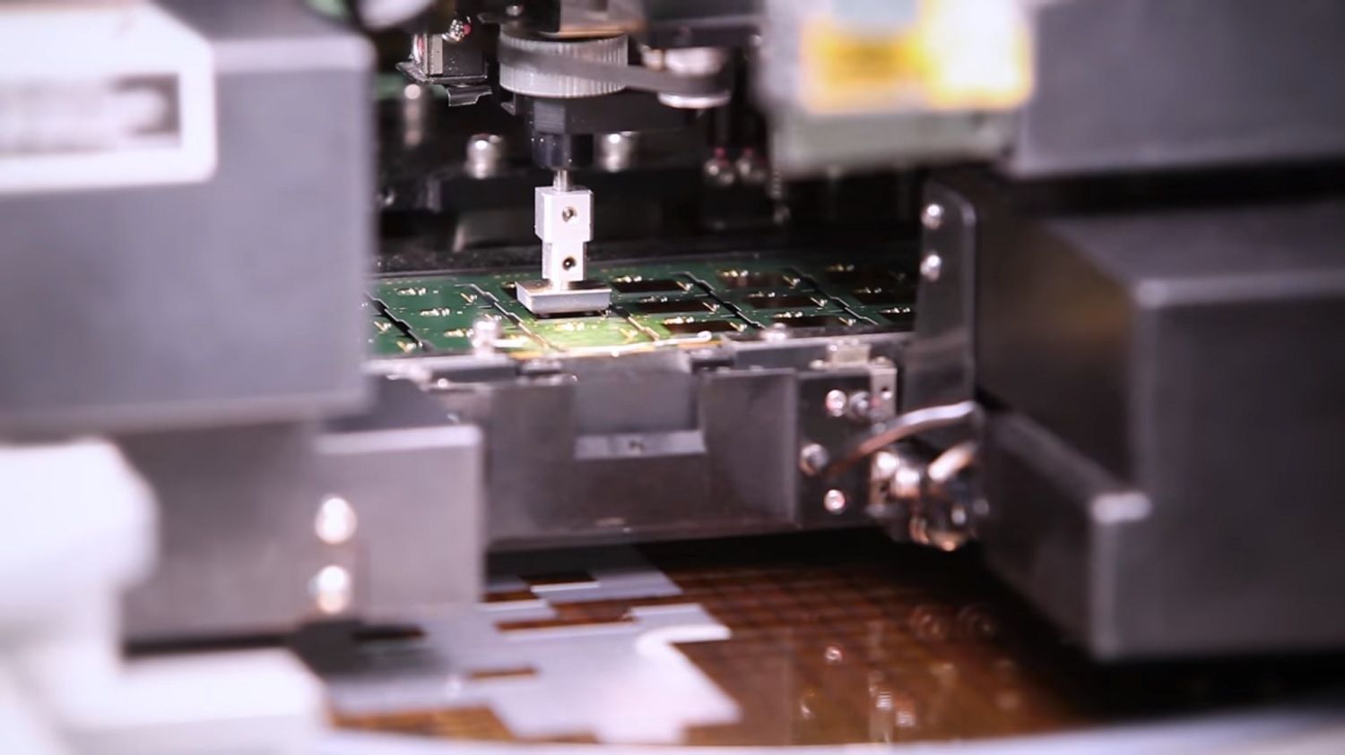 A machine picks a chip from the feeder and places it on to the PCB