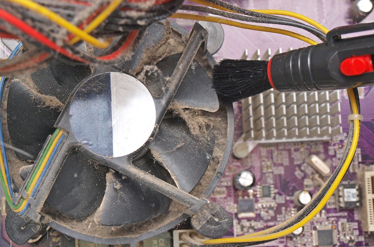 Small brush removes dust and lint from the exposed fan of a desktop computer