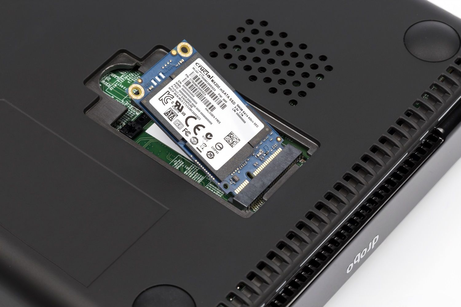 A Crucial MX200 MSATA SSD is being inserted in to a laptop