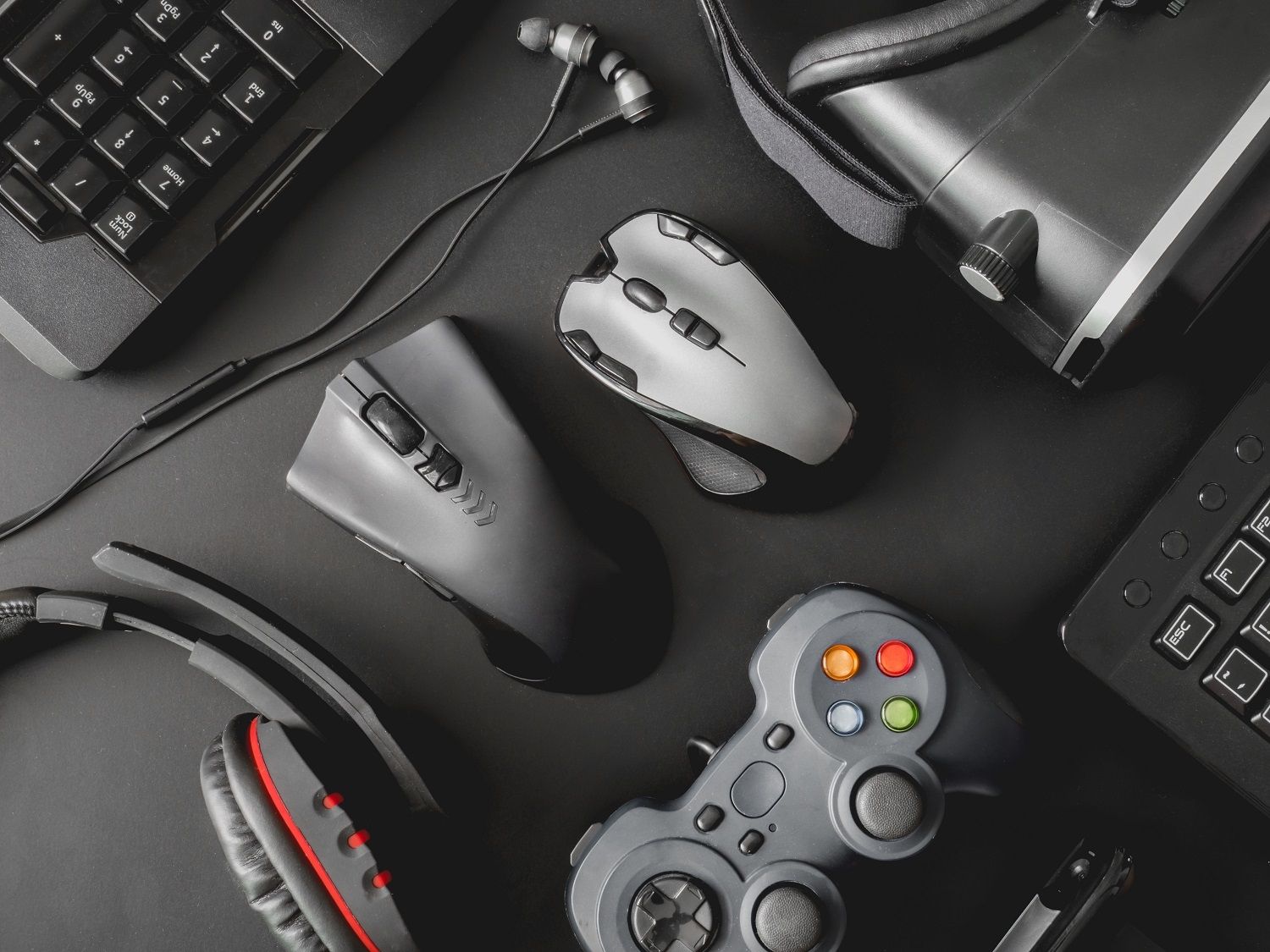 Peripherie eines Gaming-PCs mit Maus, Tastatur, Gaming-Kopfhörer, Controller und VR-Headset
